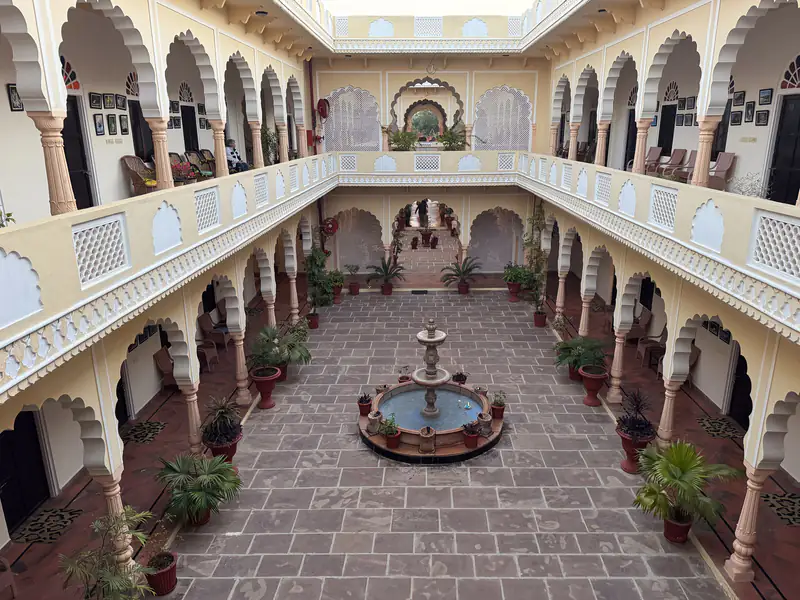 Courtyard of a heritage haveli hotel with arches and a fountain